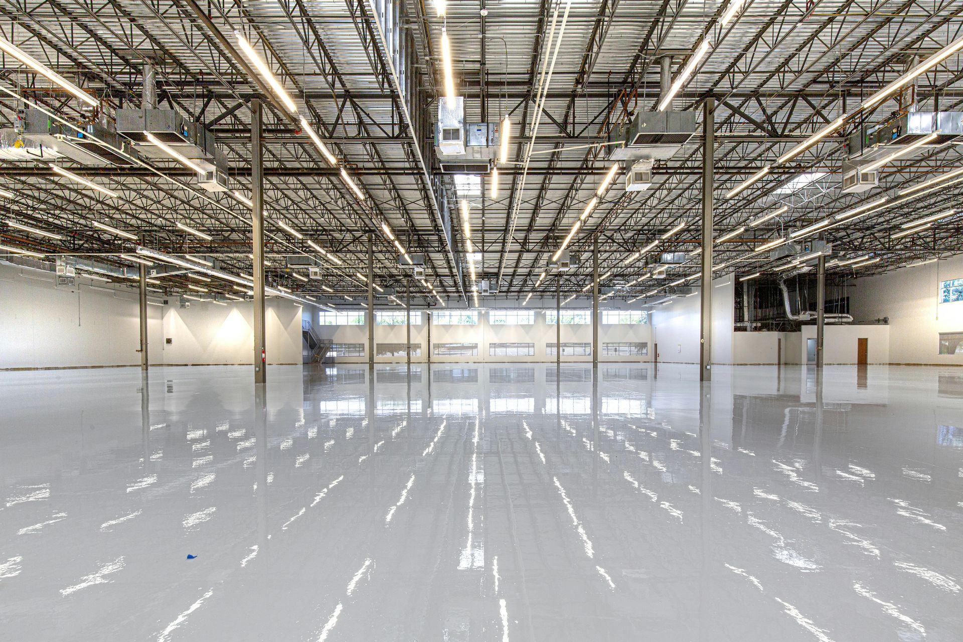 Shiny warehouse floor with overhead lights and ceiling